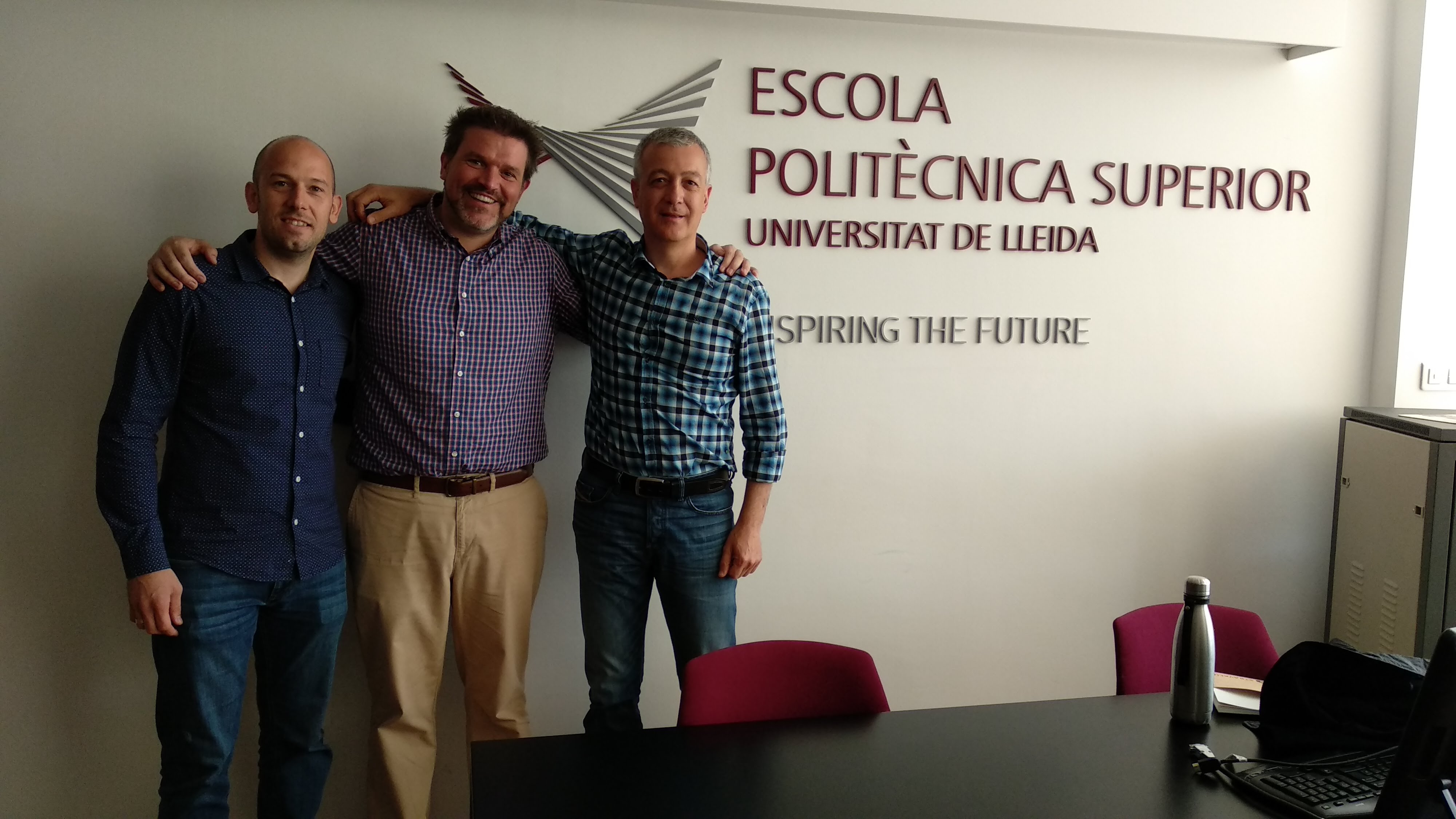 Aaron with Toni and Juan Enrique in front of the EPS logo